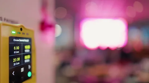 Kiosk touchscreen displaying numeric options with blurred crowd background and Stock Footage 335686051