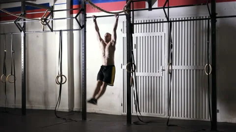 Kipping pull-ups - young man doing workout at the gym Stock Footage 65280088