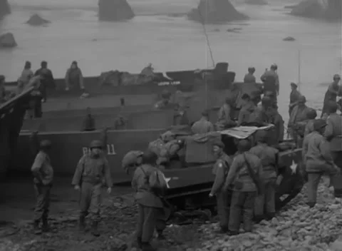 KISKA, ALASKA - 1943: Beach cargo - Troops move among stores and craft 库存影片 343788332