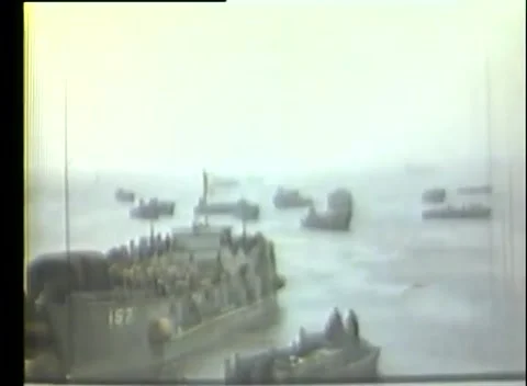 KISKA, ALASKA - 1943: Beachhead — troops massed beside a beached craft Stockbeeldmateriaal 343120116