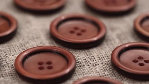 Kit large brown buttons on fabric background made of burlap. closeup rotation. Stock Footage 257208885