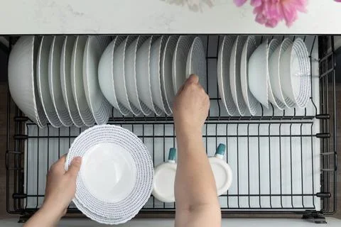 Kitchen Activity Includes Loading Clean Dishes Into a Dishwasher in a Moder.. Stock Photos