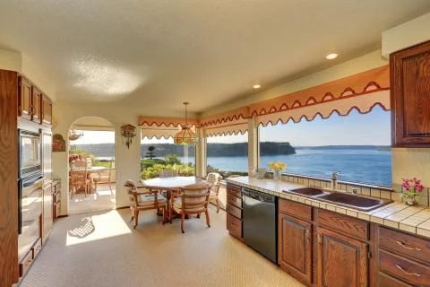 Kitchen and dining room interior with carpet flooring and arched entry. Tacom Stock Photos