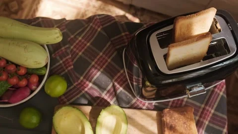 Kitchen appliances help quickly prepare buttered toasts with fresh vegetables Stock Footage 311864823