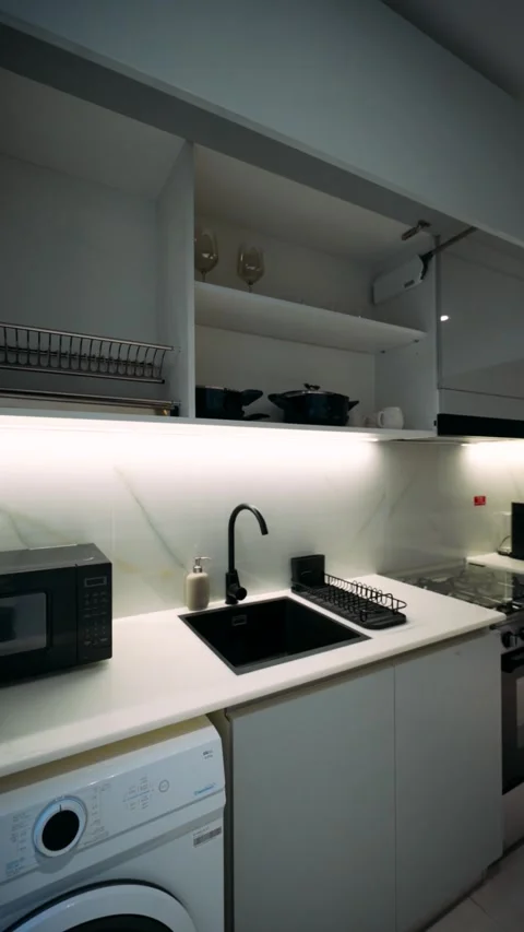 Kitchen area in the apartment with coffee machine, plumbing and washing machine 库存影片 263233475