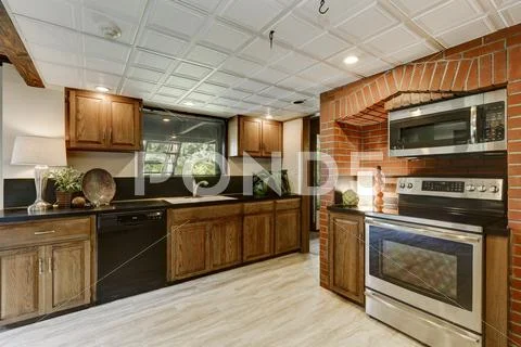 Kitchen Area With Red Brick Wall And Built In Appliances. Large Wooden House