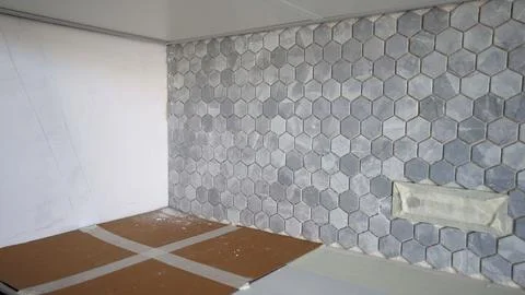 Kitchen backsplash with grey hexagonal marble tiles during home renovation. Stock Photos