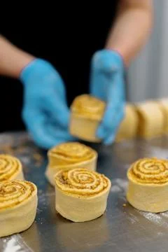 The kitchen in the bakery - the process of making cinnabons, a woman baker uses 写真素材