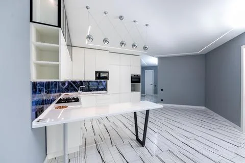 A kitchen with a blue marble backsplash and white cabinets Stock Photos