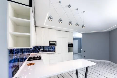 A kitchen with a blue marble backsplash and white cabinets Stock Photos