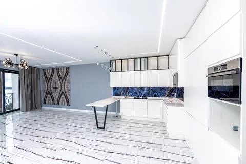 A kitchen with a blue marble backsplash and white cabinets Stock Photos
