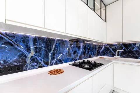 A kitchen with a blue marble wall and a white countertop Stock Photos