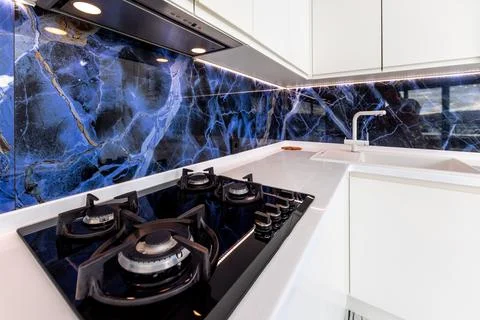 A kitchen with a blue marble wall and a white countertop Stock Photos