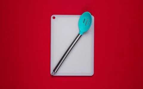 Kitchen board with kitchen spoon on red background. Asian cuisine 库存照片