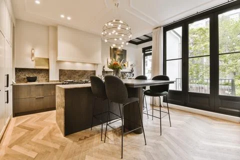 A kitchen with a breakfast bar and a large window Stock Photos