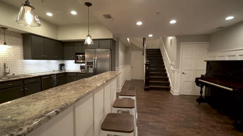 Kitchen breakfast bar with stools staircase and piano Stock Footage 345691312