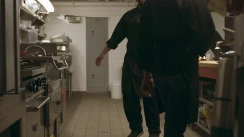 Kitchen brigade working in industrial kitchen with soft interior lighting. Close Stock Footage 199461739