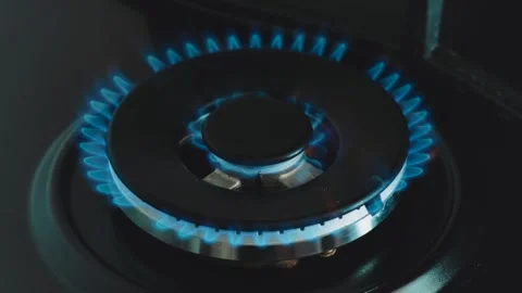 Kitchen burner is ignited in a bright blue flame, fire for cooking. Background Stock Footage 337898154