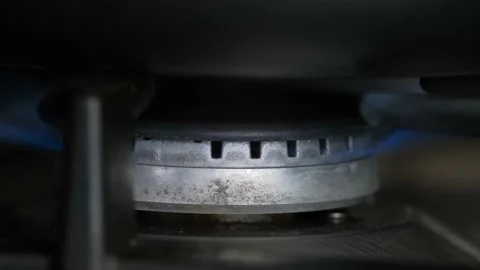 A kitchen burner lights up a blue flame. Natural gas ignition, close-up. Stock Footage 147990623