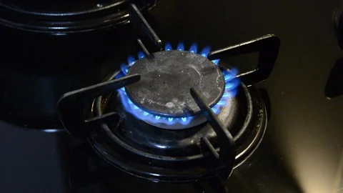 Kitchen burner turning on. close up on the flame. black stove. Видео 90763693