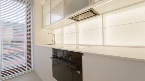 Kitchen cabinet LED backlight turning on over built-in stove and black oven Stock-Footage 335540750