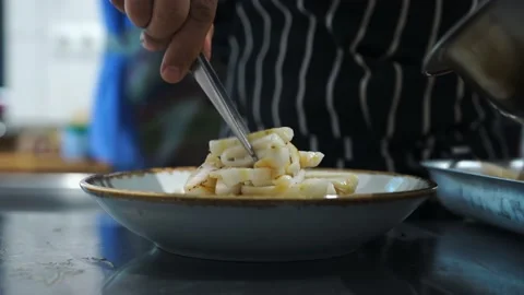 Kitchen chef lays pizza on a plate of fried squid for restaurant guests Stock Footage 141105970