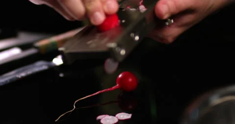 Kitchen Chef is slicing a radish on a manual slicer. Shot in slow motion with Stock Footage 156630802