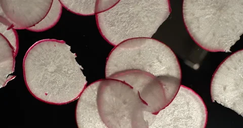 Kitchen Chef is slicing a radish on a manual slicer. Shot in slow motion with Stock Footage 156630852