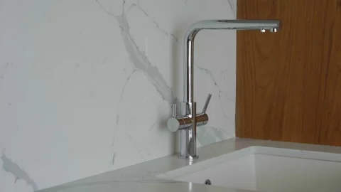 Kitchen close-up video with marble countertop, chrome faucet Vidéo 321948987