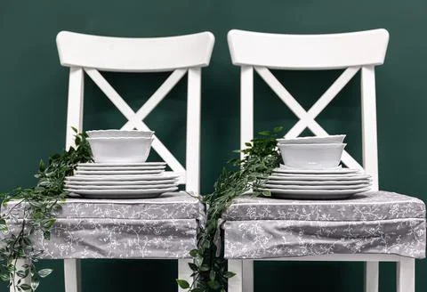 Kitchen composition with a set of dishes on white chairs. Stock Photos