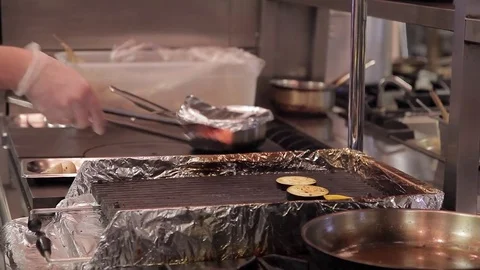 In the kitchen, the cook is laying large vegetables on the grill Stock Footage 75817402