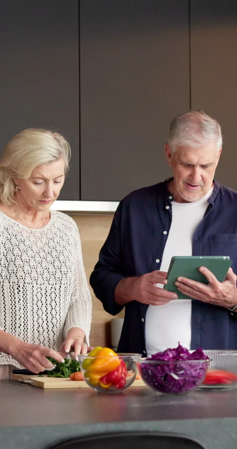 Kitchen, cooking and old couple with tablet, cut vegetables and organic recipe Stock Footage 336857205