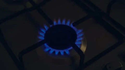 Kitchen cooktop gas burner with blue flame in dark room Stock Footage 208865656