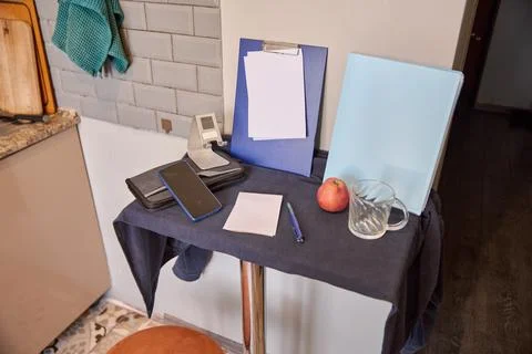 Kitchen corner table with smartphone, clipboard, apple, glass and notepad u.. Stock Photos