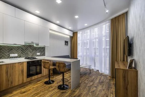 A kitchen with a counter and two stools, and a couch in the living room Stock Photos