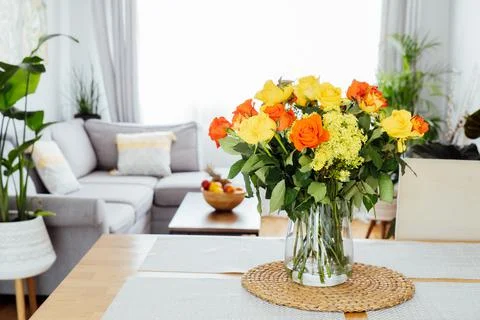 Kitchen counter table with focus on vase with yellow and orange roses on it with Stock Photos