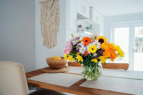 Kitchen counter table with focus on vase with huge multicolor various flower Stock Photos