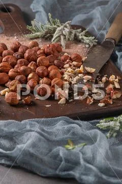 Kitchen cutting board with hazelnuts without shell, view from above. Stock Photos