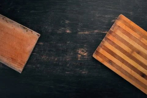 Kitchen cutting board. Top view. On a black wooden background. Copy space. Stock Photos