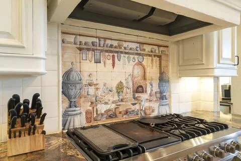 Kitchen with decorative backsplash and modern appliances in bright setting Stock Photos