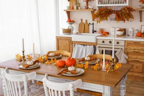 Kitchen, dinning table decorated with pumpkin, candle and leaves for Hallow.. Stock Photos