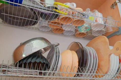 Kitchen dish rack full of drying cups and plates Stock Photos