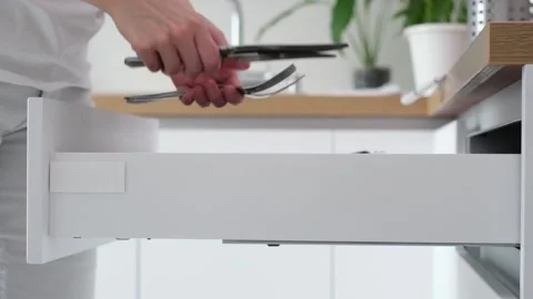 Kitchen drawer opens smoothly, revealing a collection of cutlery being retrieved Stock Footage 315660873