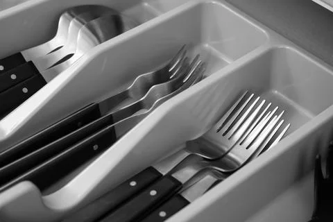 Kitchen drawer organizer with assorted silverware and utensils, home organiza Stock Photos
