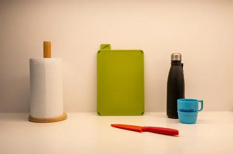 Kitchen essentials arranged neatly with a patterned teal mug, cutting board.. 库存照片