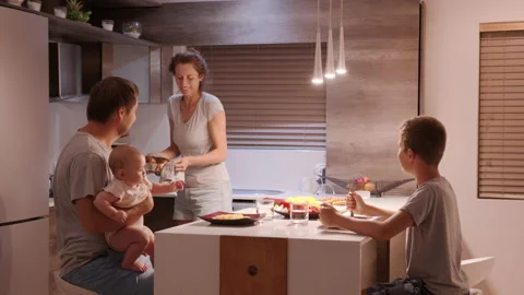 In the Kitchen: Family of Four having supper Together. Mother, Father, Boy and Stock Footage 149177199