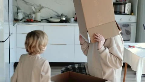 In the kitchen, father and son take out boxes and play around Stock Footage 305942948