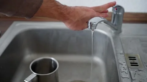 This kitchen faucet offers a steady water flow and hand feature, enhancing Stock Footage 302658853