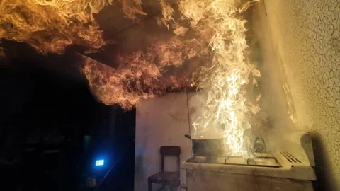Kitchen fire safety demonstration, firefighter pouring water on burning oil pot Stock Footage 337713002