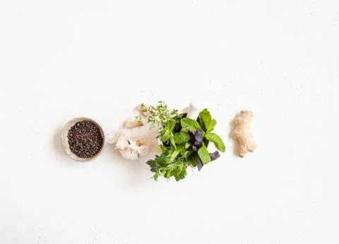 Kitchen flat lay background of ginger, black pepper in bowl, fresh garlic and Stock Photos